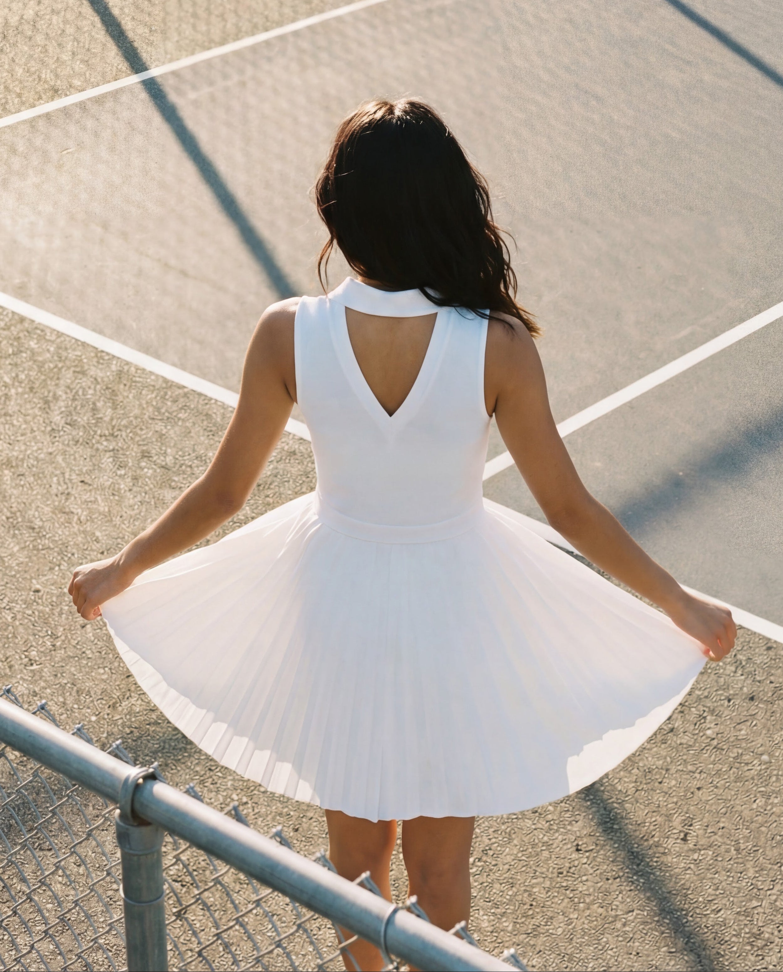 Woman in a white dress standing on a tennis court