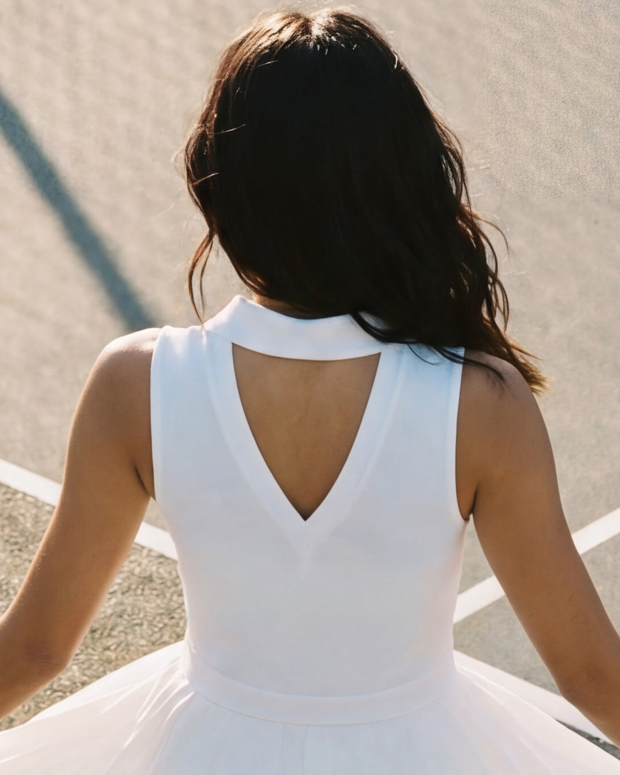Woman in a white dress standing on a tennis court