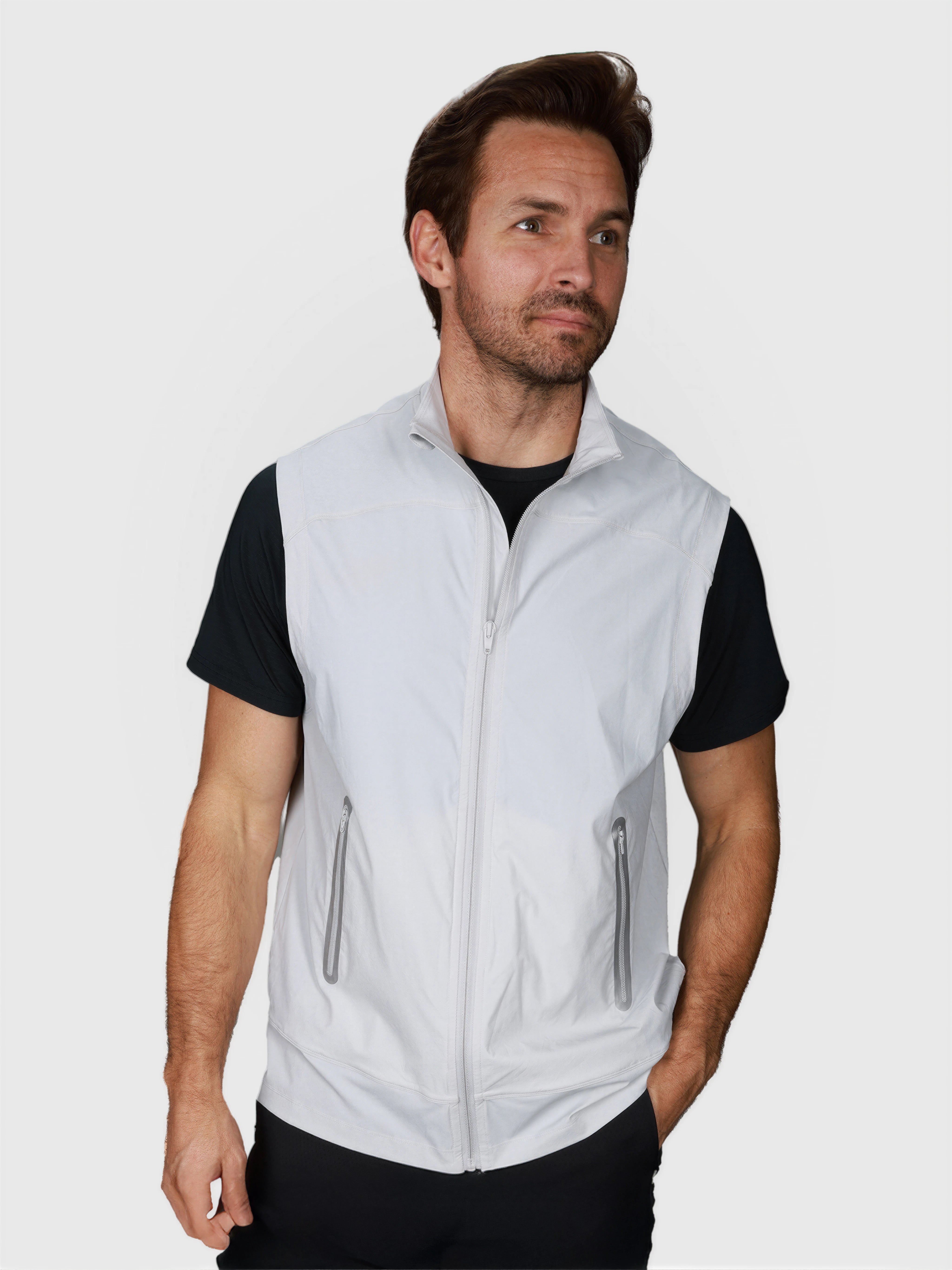 Man wearing white J Sas Vest by MUEV styled for padel and pickleball apparel over a black shirt