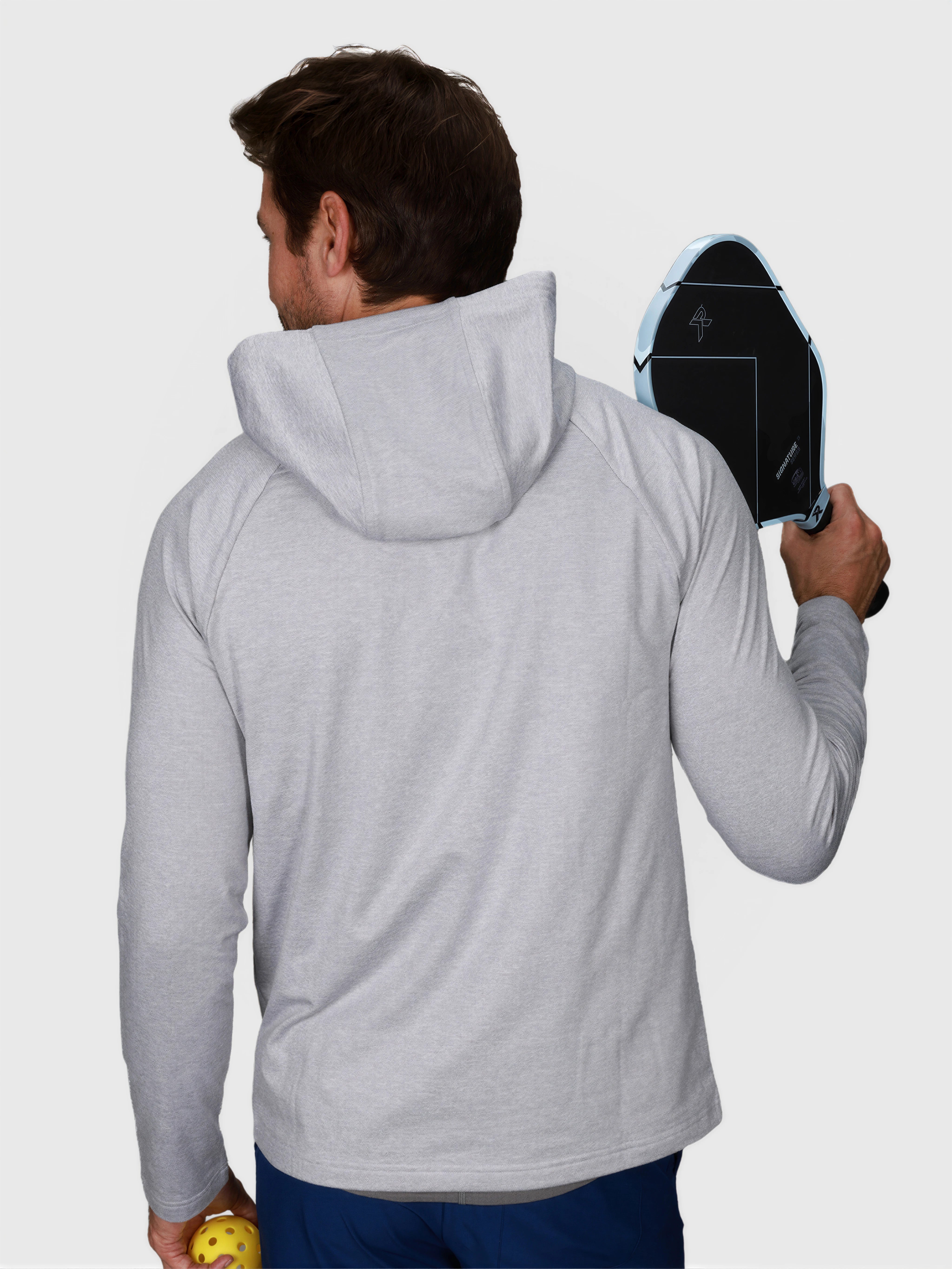 Man wearing Heather Gray Pro Serve Hoodie by MUEV holding pickleball paddle and ball back view