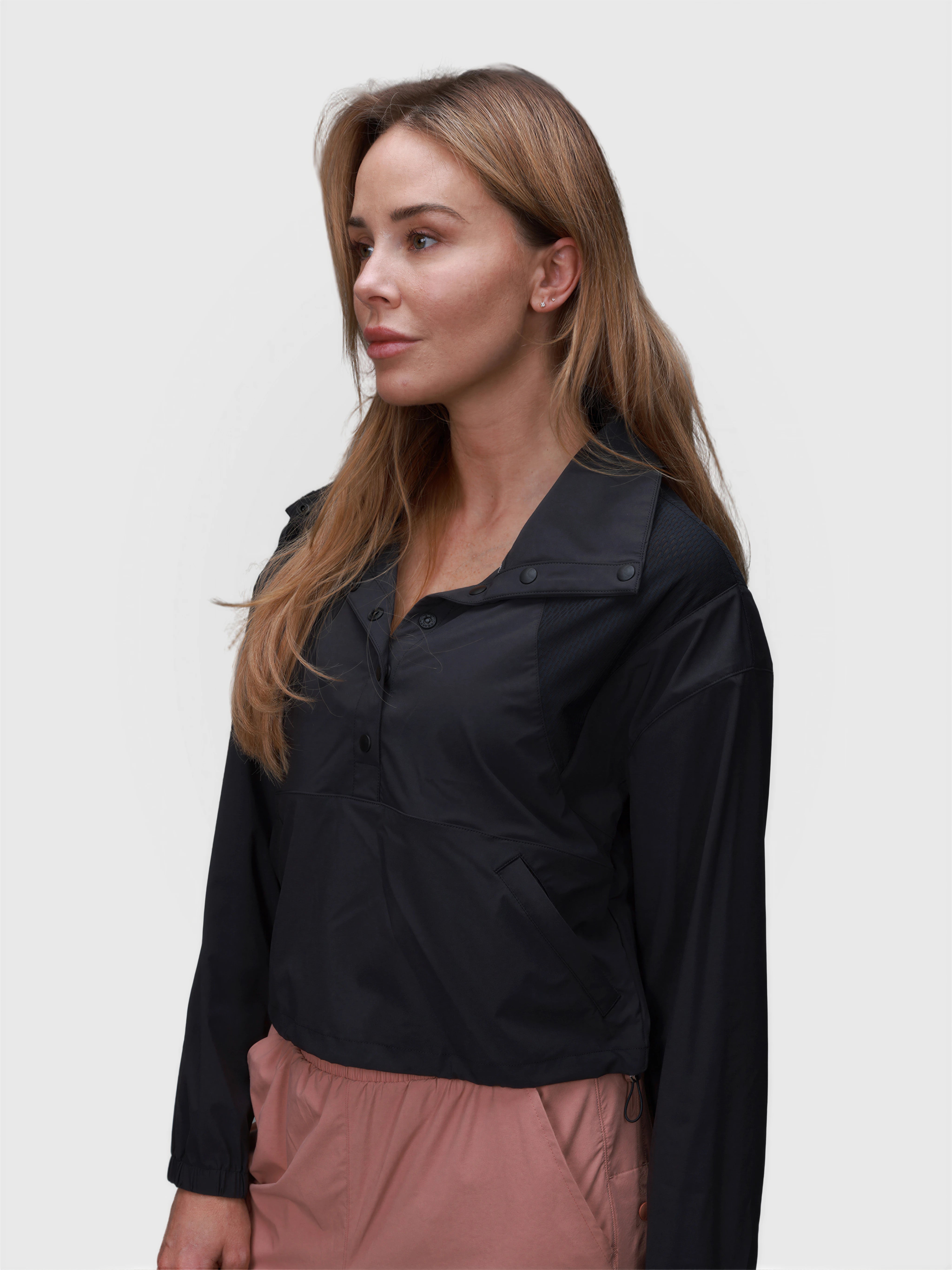 Woman wearing black E Sas Crop Jacket by MUEV styled for padel and pickleball apparel