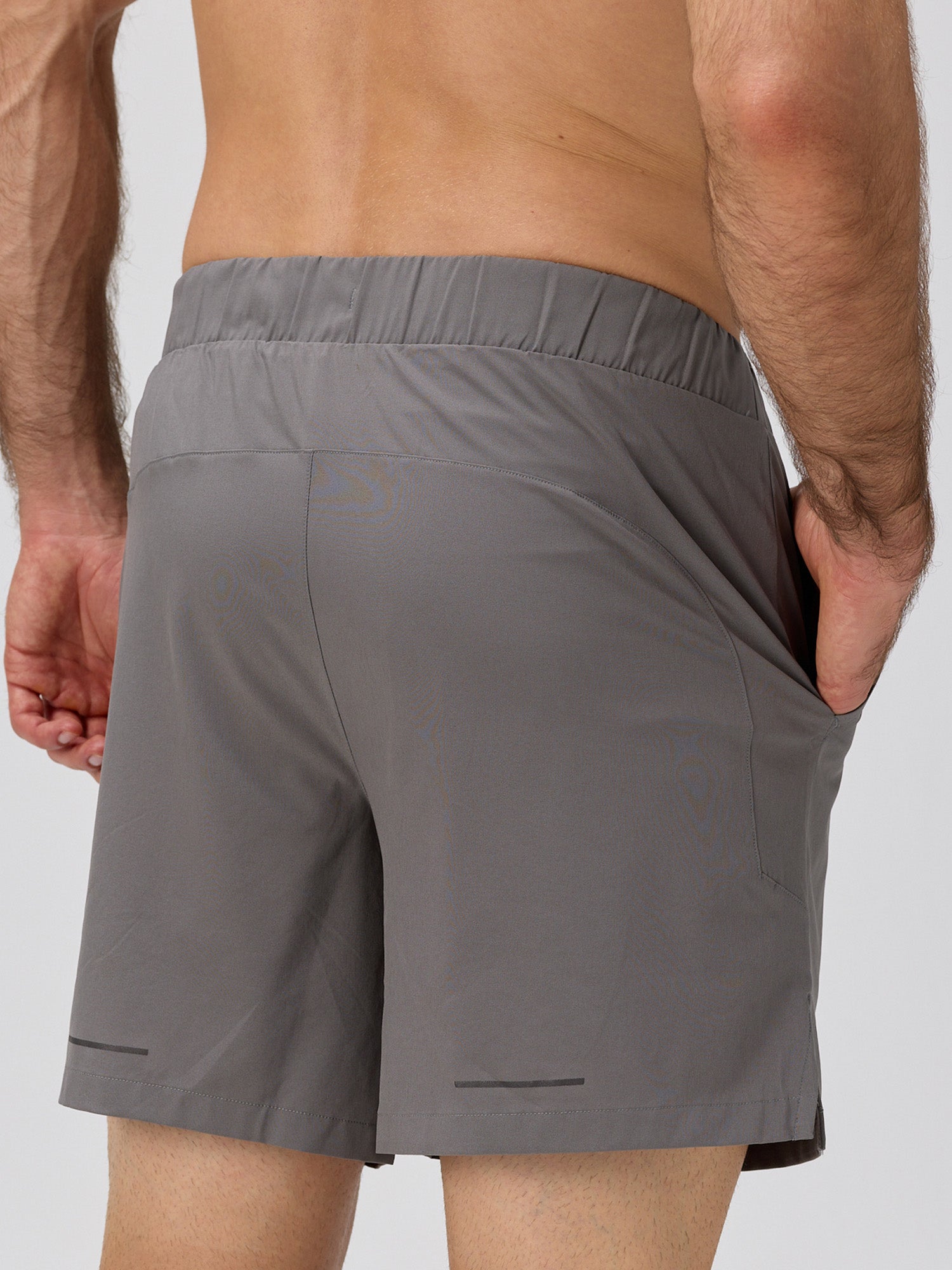 Rear view of pewter gray athletic shorts with elastic waistband, side pockets, premium stretch fabric, and 6" inseam designed for padel and pickleball by MUEV