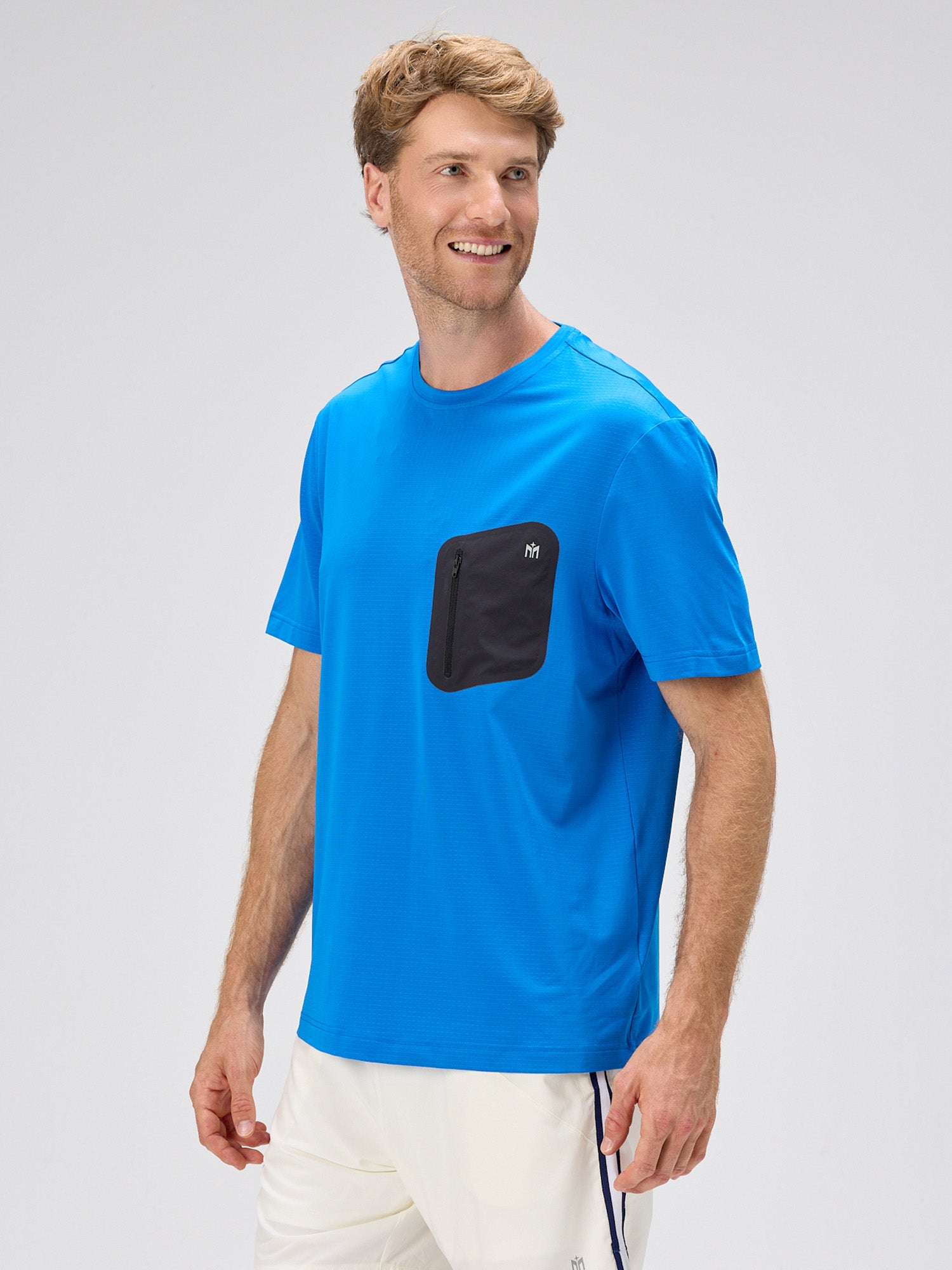 man wearing royal blue breathable tee with horizontal micro perforations and contrasting black bonded chest pocket in active pickleball apparel