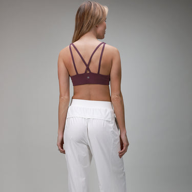 back of white pleated pant and plum bra 