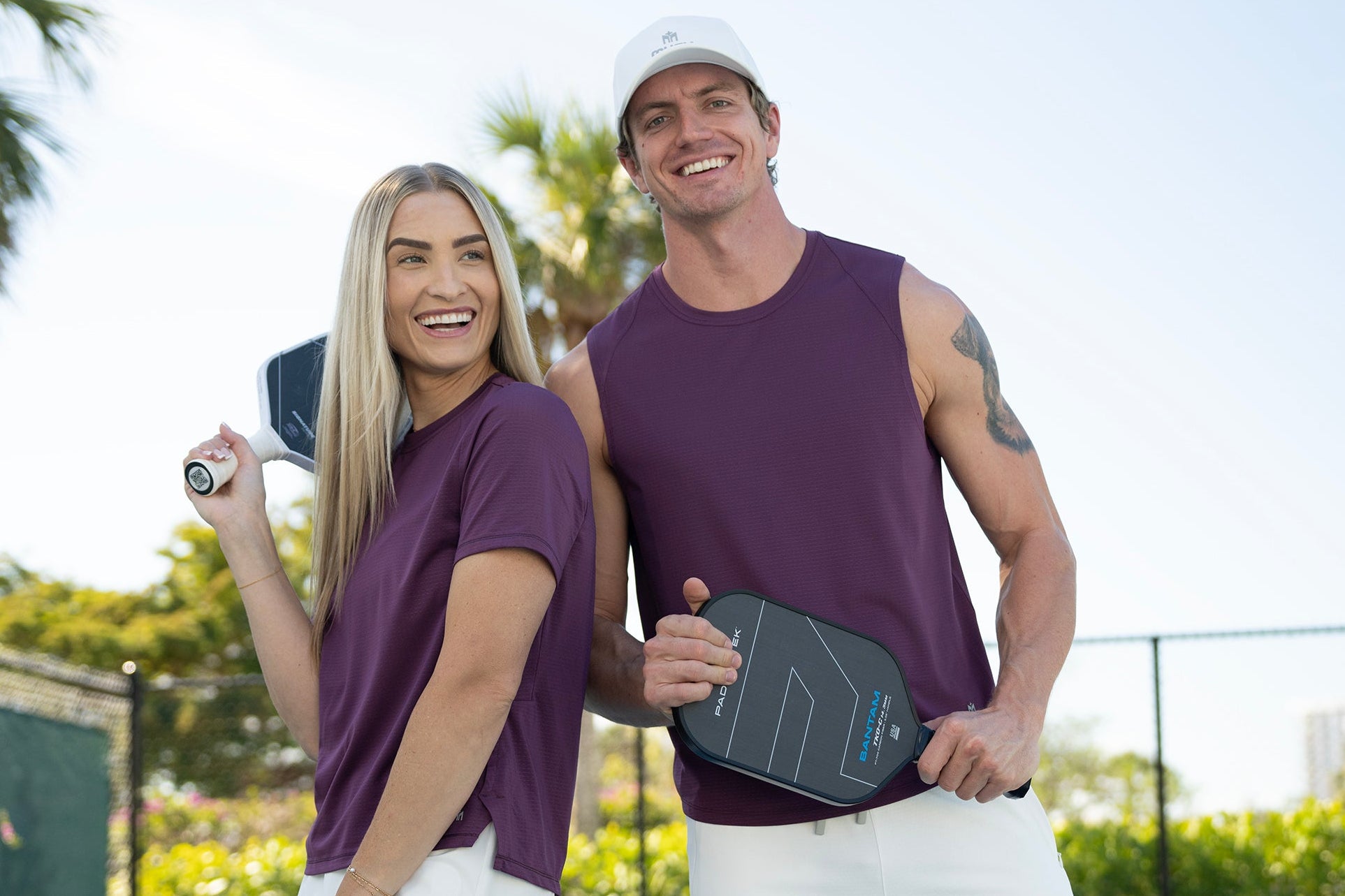 Two people on a pickleball court holding paddles
