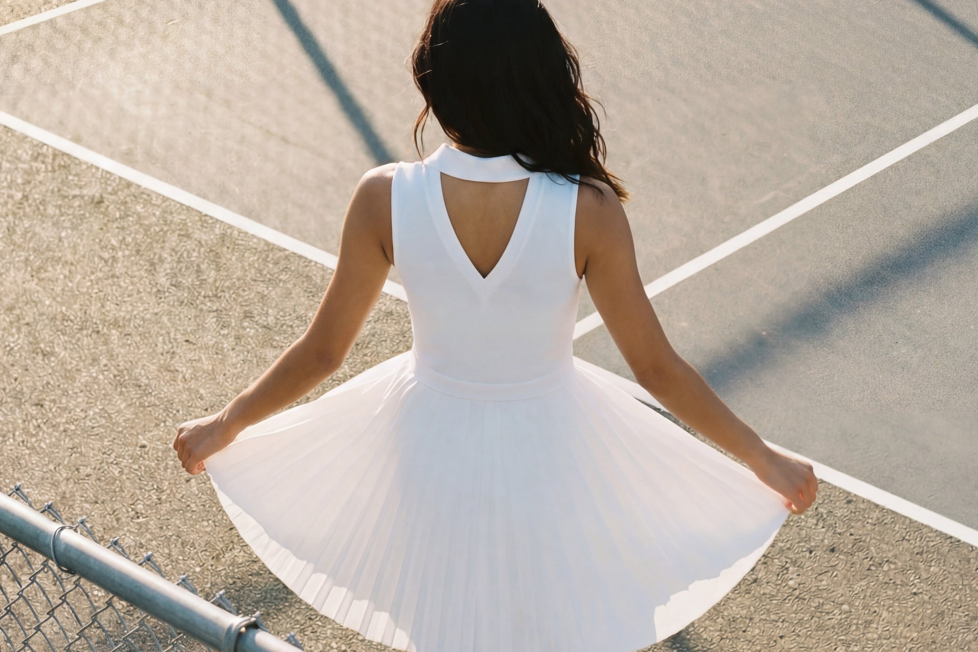 Woman in a white dress standing on a tennis court