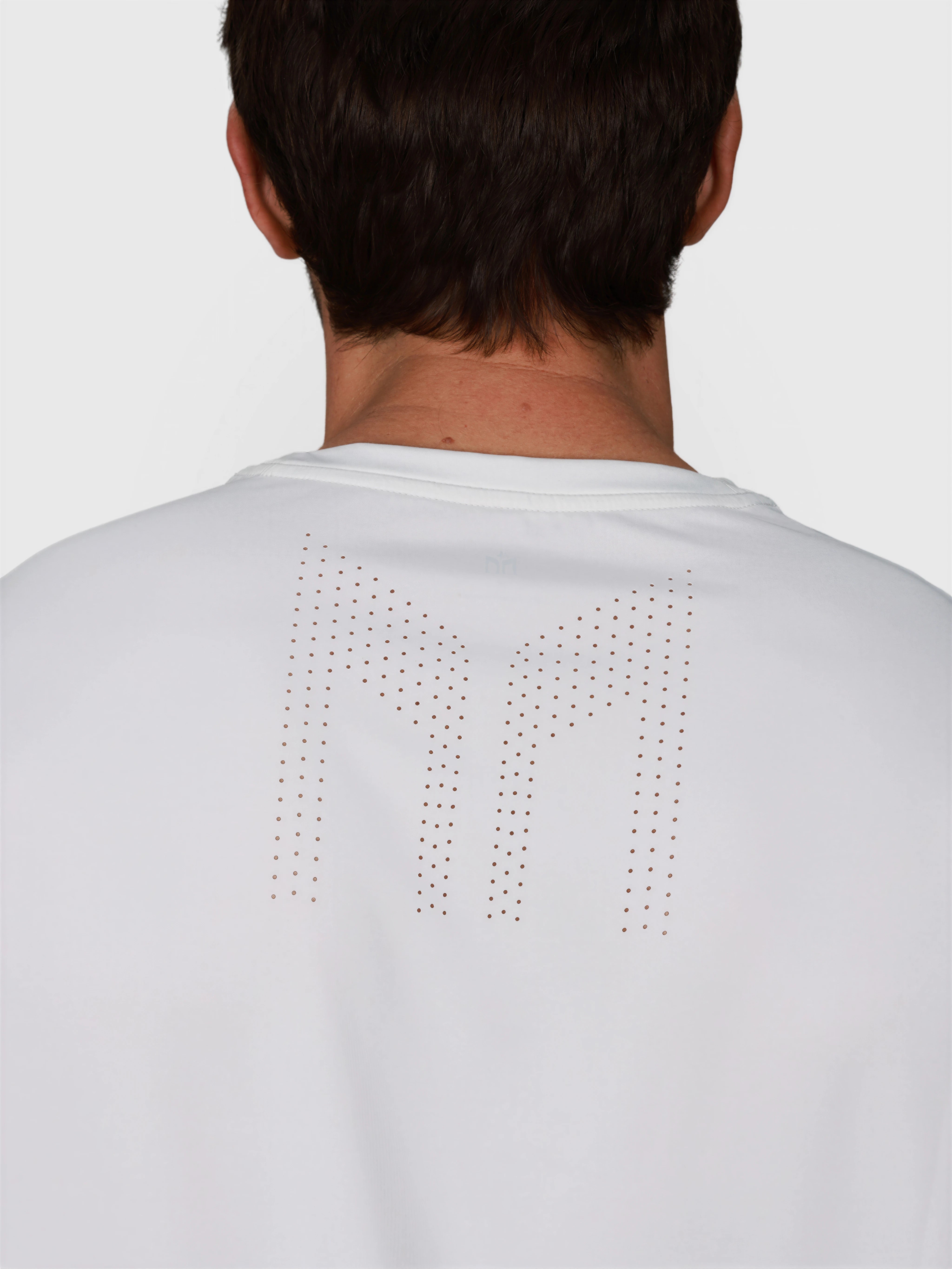 close-up of back view of man wearing white Chevron Tee by MUEV designed for padel and pickleball clothing