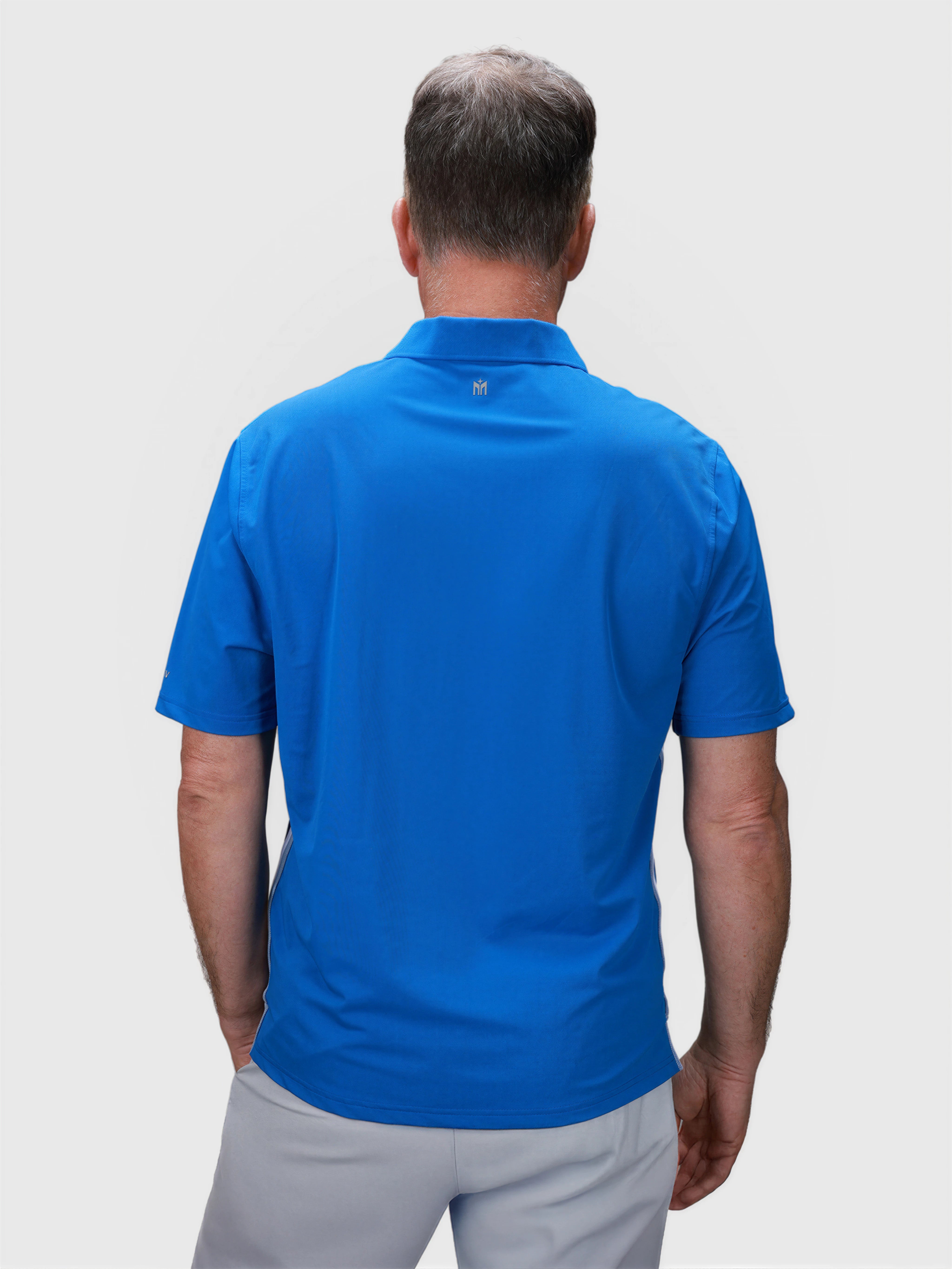 Man wearing blue Tip Polo shirt shown from back in pickleball apparel collection by MUEV