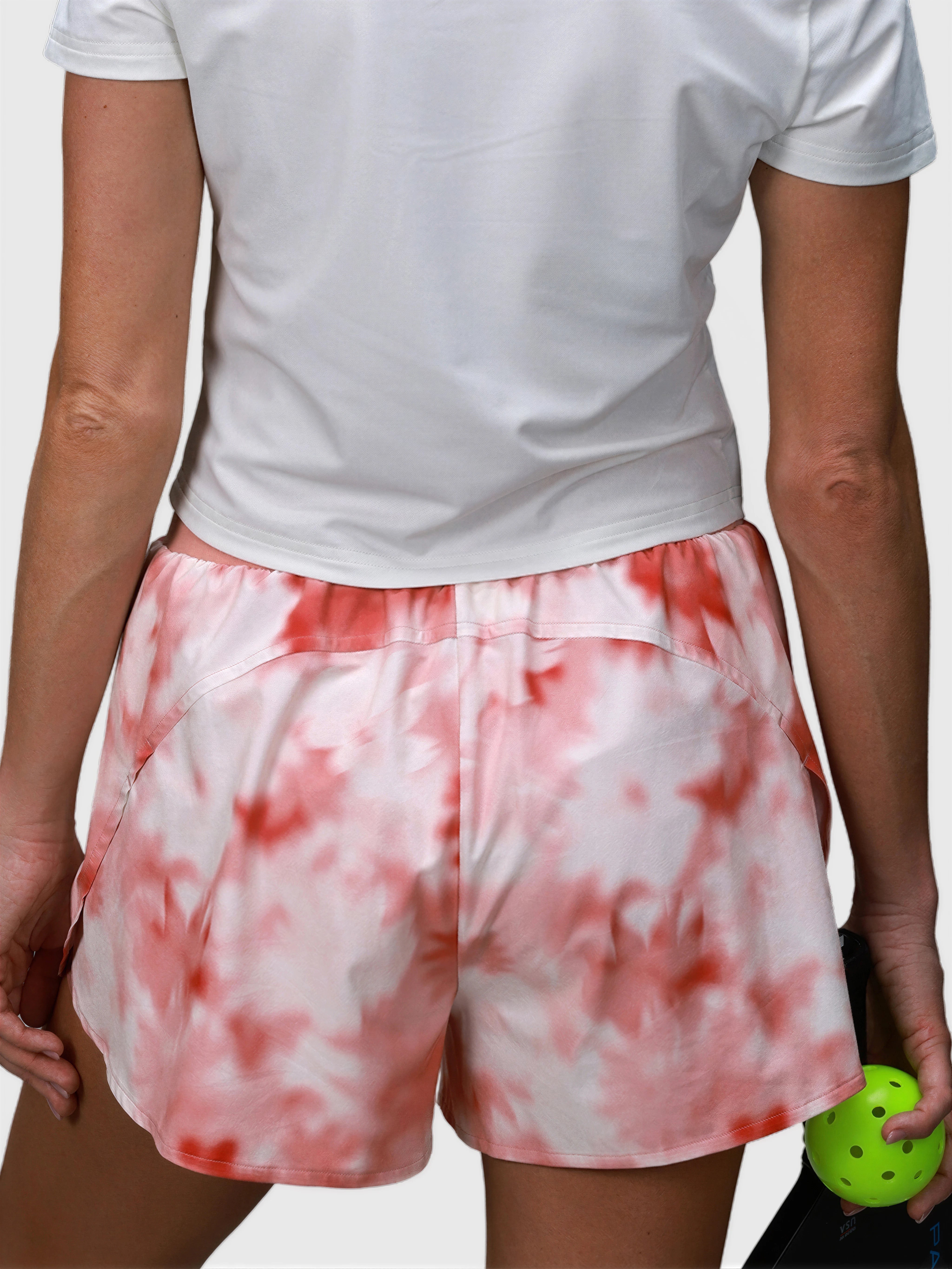 Rear view of woman wearing pink petal Tulip Compression Short in padel and pickleball apparel by MUEV