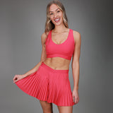 front of pink tanklette and pleated skirt 