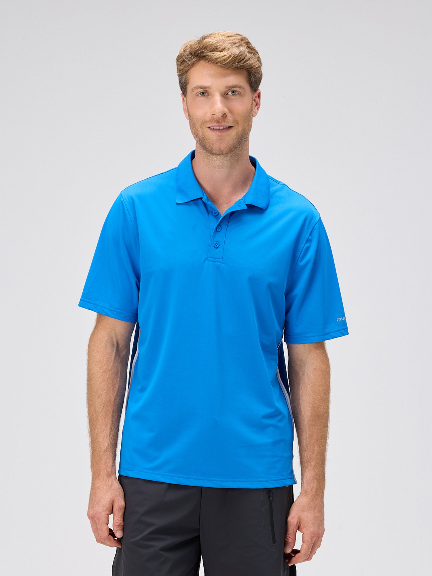 man wearing a royal blue moisture-wicking polo designed for padel and pickleball with a classic collar and short sleeves