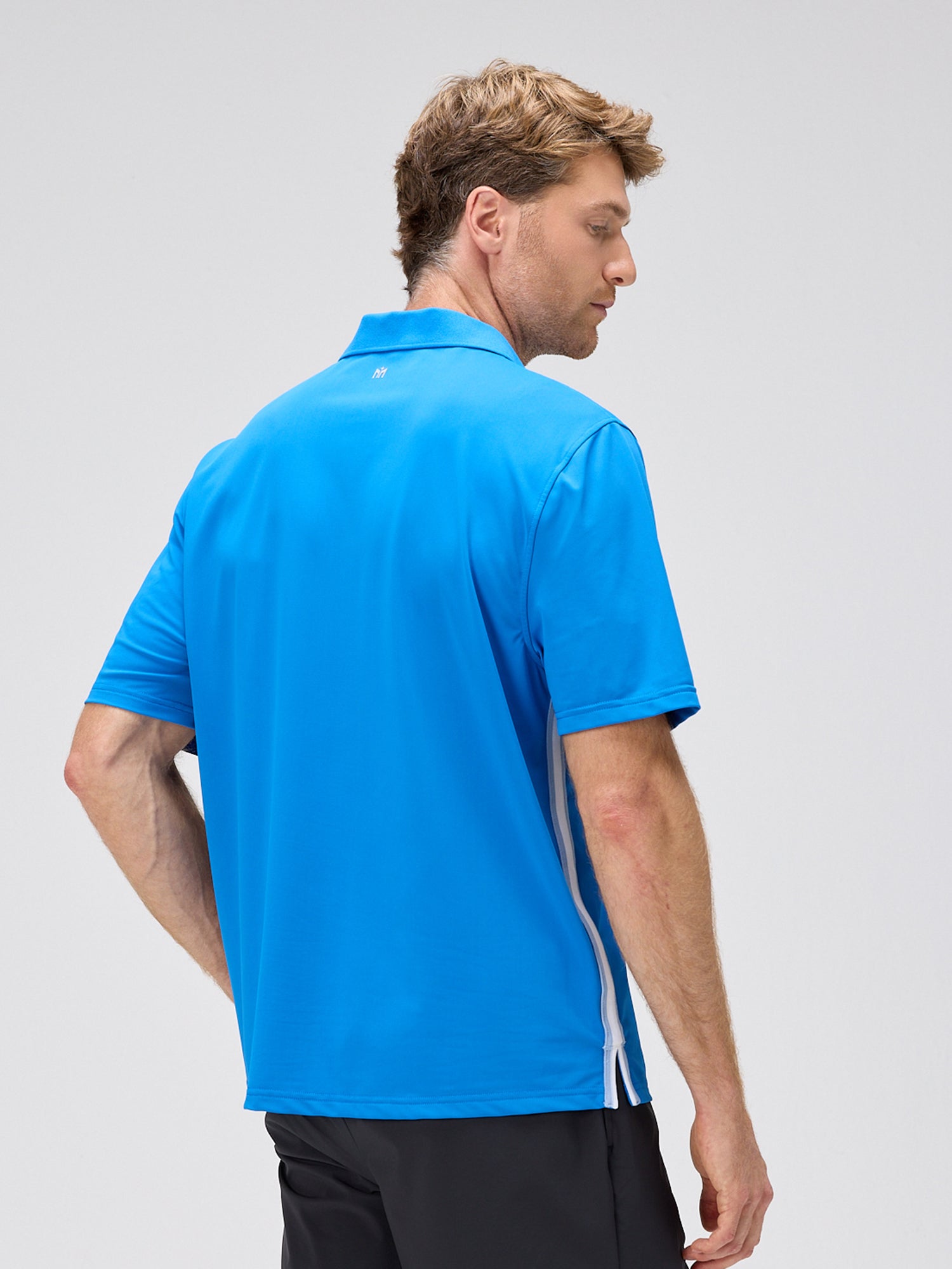 man wearing royal blue polo with moisture-wicking fabric and 4-way stretch, viewed from the back in pickleball apparel