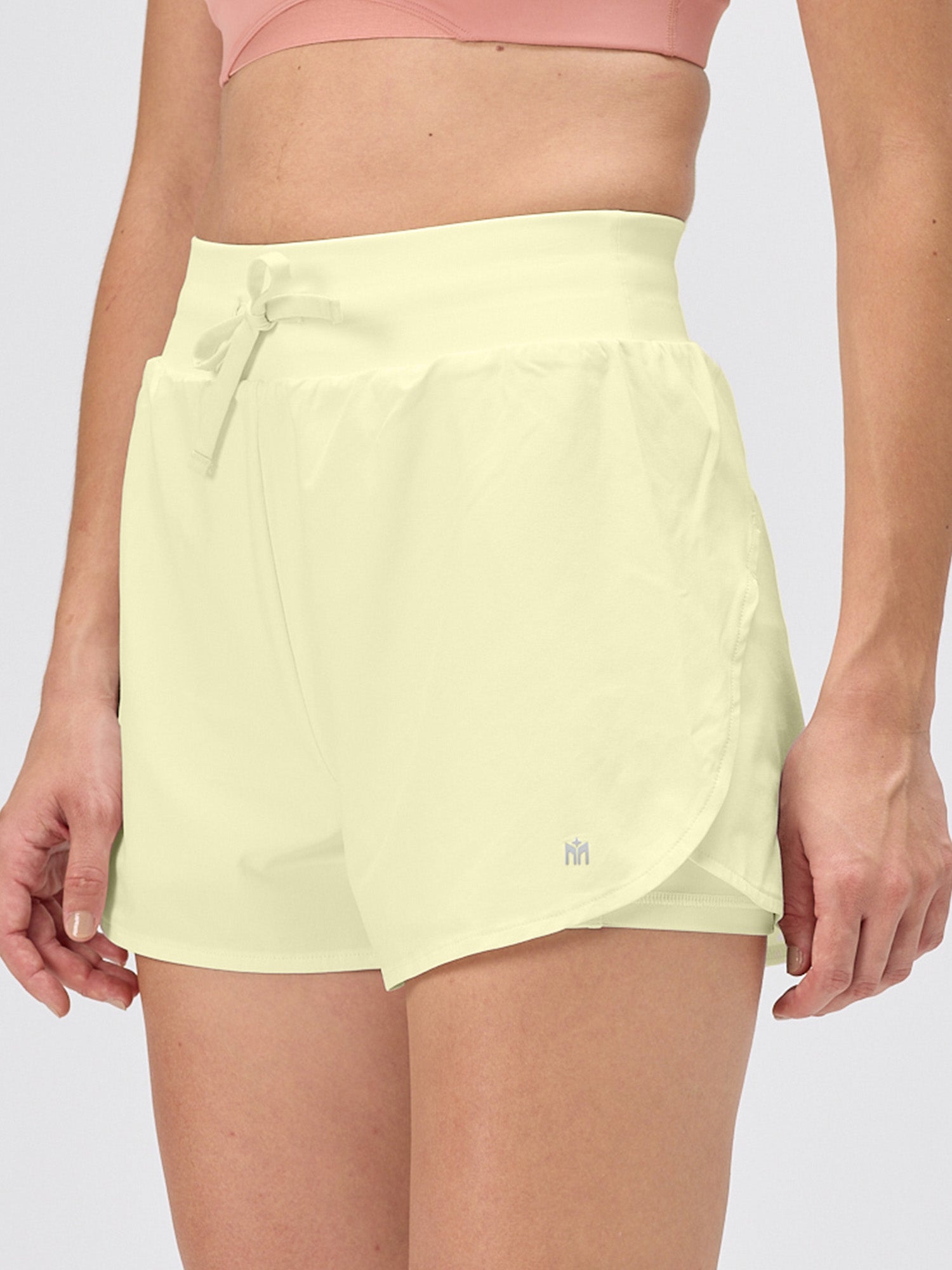 Light green athletic shorts worn by a person on a plain background
